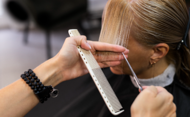 Stylist preparing a woman for a haircut in a modern Abbotsford salon